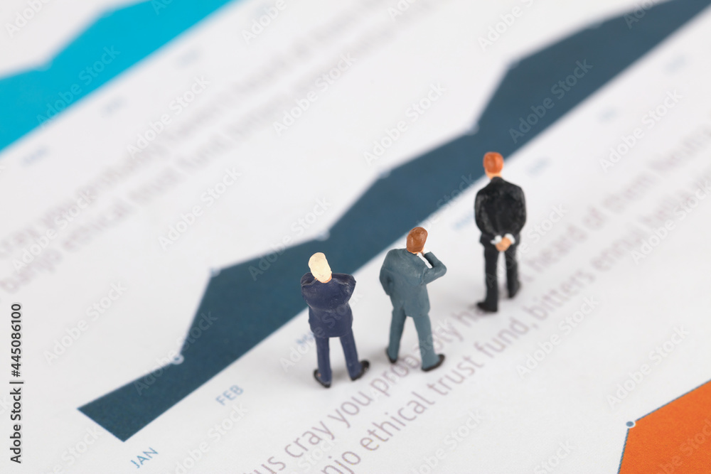 Fototapeta premium Businessman standing on financial charts thinking about problems