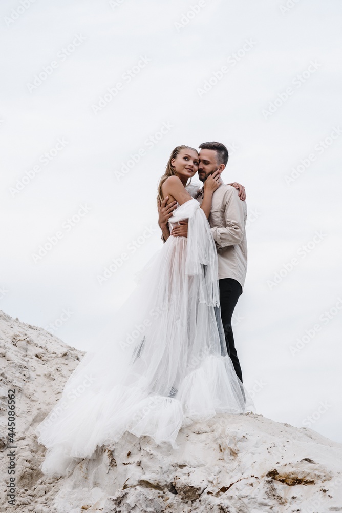 Beautiful wedding couple bride and groom at wedding day outdoors at ocean beach. Happy marriage couple o Beautiful wedding couple bride and groom at wedding day outdoors at ocean beach. Happy marriage couple o