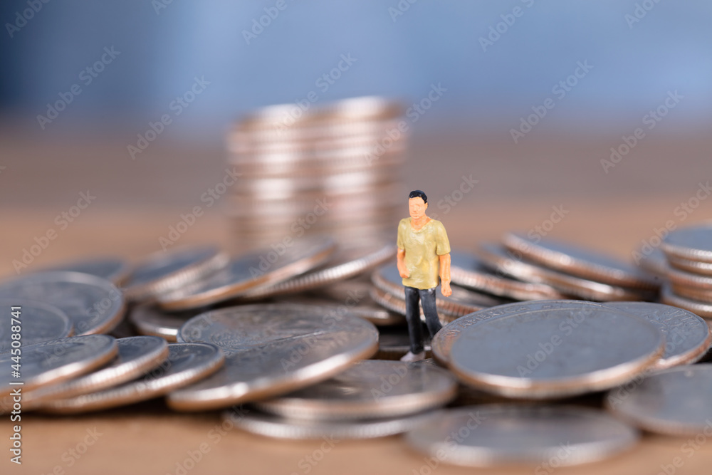 Fototapeta premium Doll model standing in coin pile