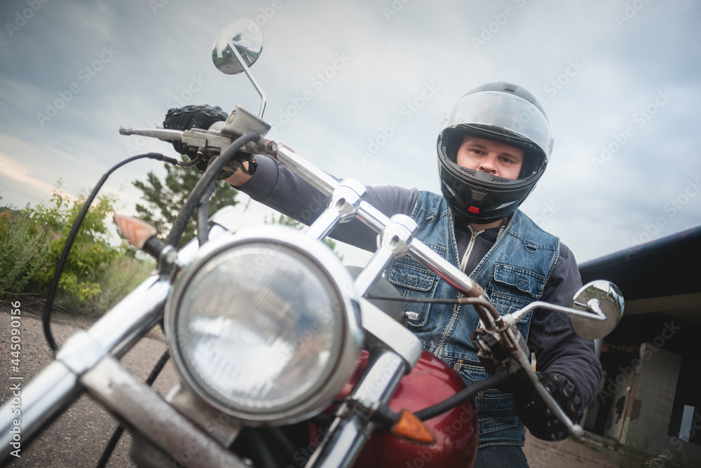Biker in the helmet is sitting on the motorbike. Biker in the helmet is sitting on the motorbike.