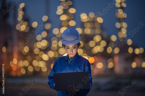 Business women in uniform and helmet young women engineer concept using tablet working on social network with industry background.