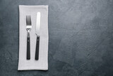 Fabric napkin and cutlery on dark background