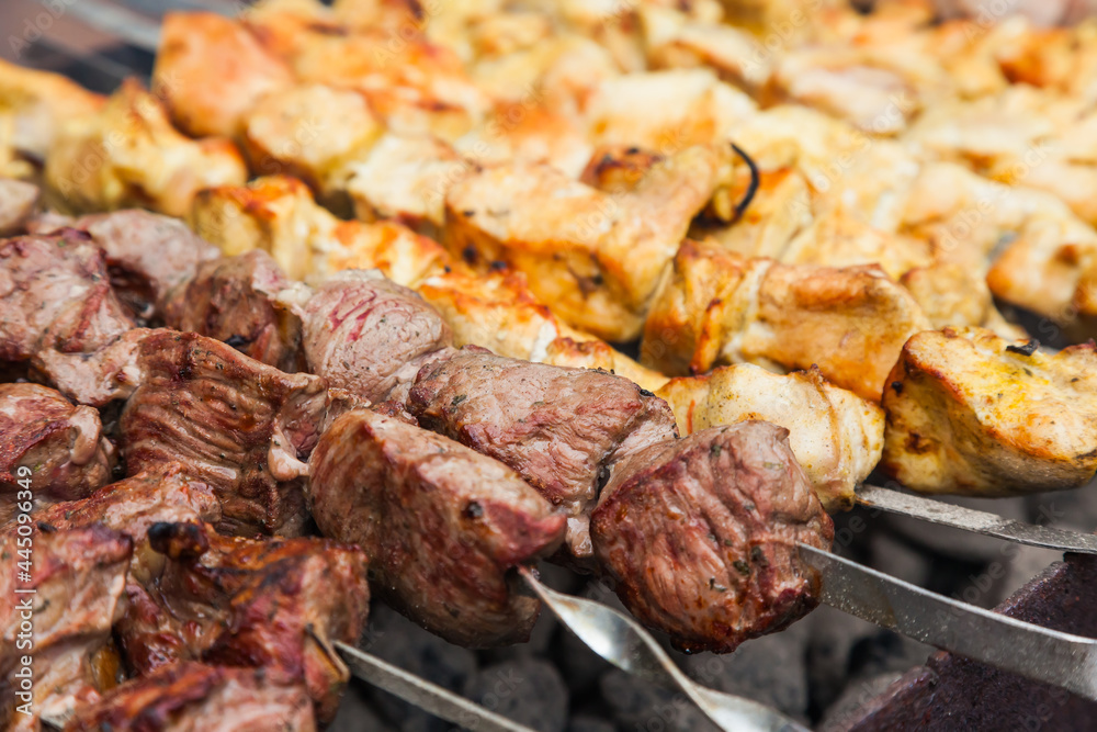 Background of chicken and lamb cut into pieces and fried on the grill. Fried kebab background with chicken and lamb.