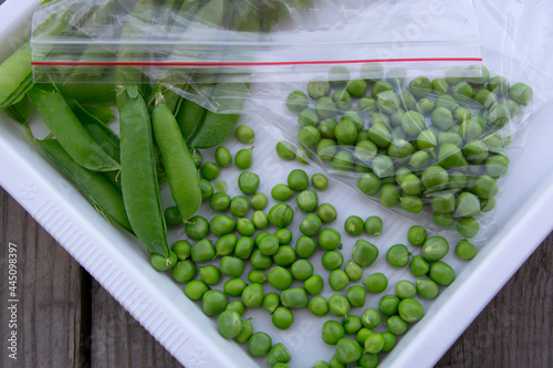 Green peas are in a bag on a white tray. Harvesting fresh vegetables from the garden. Close-up.