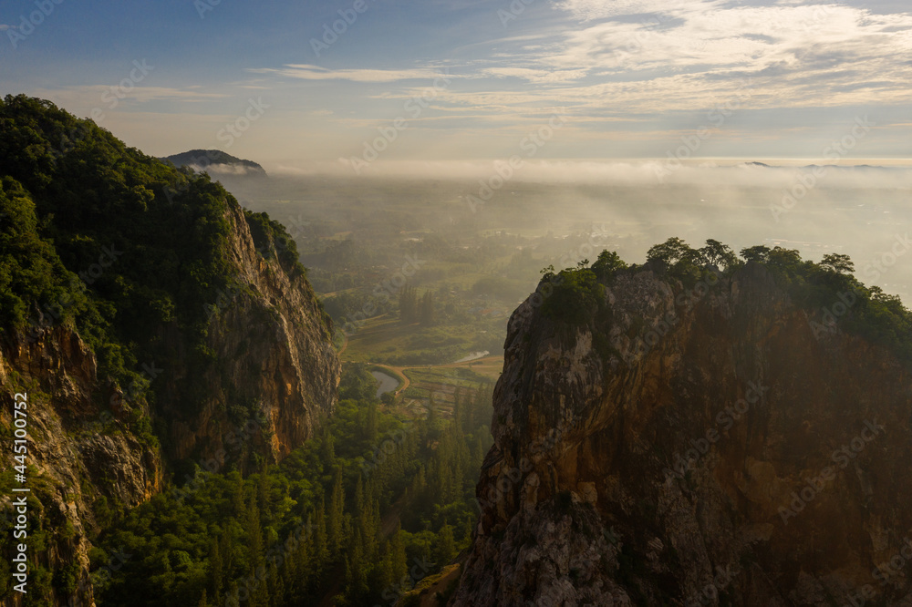Panorama Aerial view Drone shot of Beautiful scenery landscape sunlight in the morning sunrise above flowing fog waves on mountain peak 
