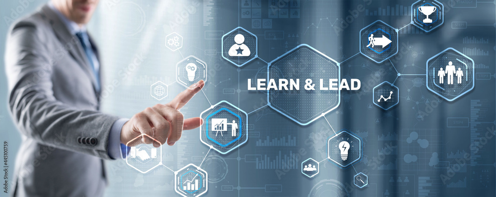 Learn and Lead. Businessman presses hand on the virtual screen inscription Learn and Lead. Businessman presses hand on the virtual screen inscription
