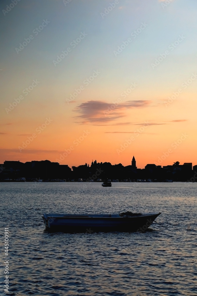 Naklejka premium Small boat and beautiful sunset over Stobrec, Croatia.