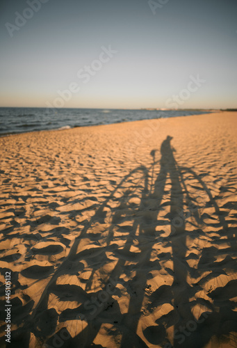 Shadow of cyclist with bicycle on the sand beach. Concept of freedom on the seashore