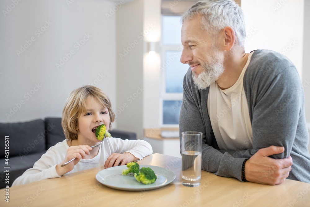 Mature man and his son having breakfast together