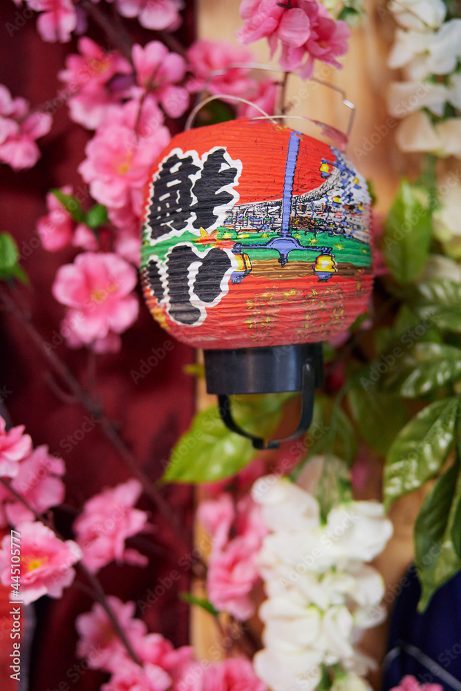 Blurred red and pink Japanese-style background with hieroglyphs, lantern and pink flowers