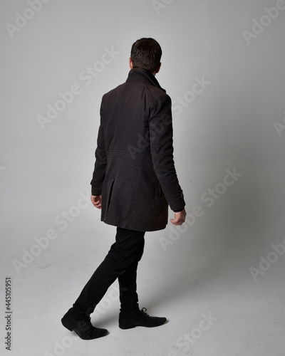 Photography Full length portrait of a brunette man wearing black leather coat