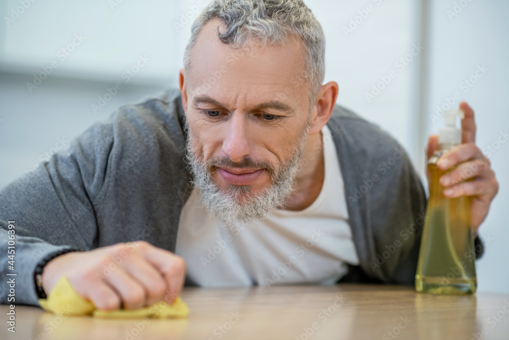 Man in homewear doing housework and looking busy