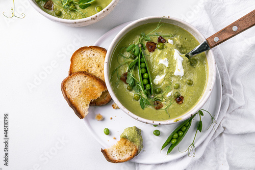 Cream of green peas soup with toasts and sour cream.