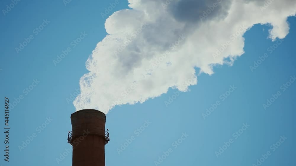 Red Brick Production Pipe with White Smoke against A Bright Blue Sky. Concept Air Emissions, Environmental and Air Pollution Red Brick Production Pipe with White Smoke against A Bright Blue Sky. Concept Air Emissions, Environmental and Air Pollution