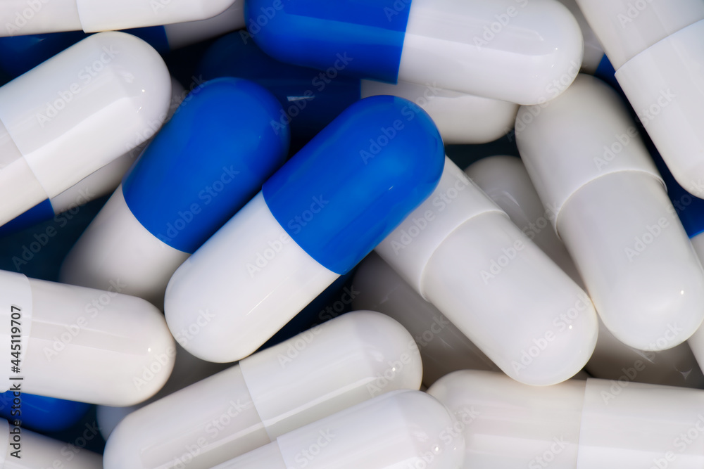 Close-up Heap of medical pills in white and blue colors. Macro medical background of bi-color drug. Concept of healthcare and medicine. Close-up Heap of medical pills in white and blue colors. Macro medical background of bi-color drug. Concept of healthcare and medicine.