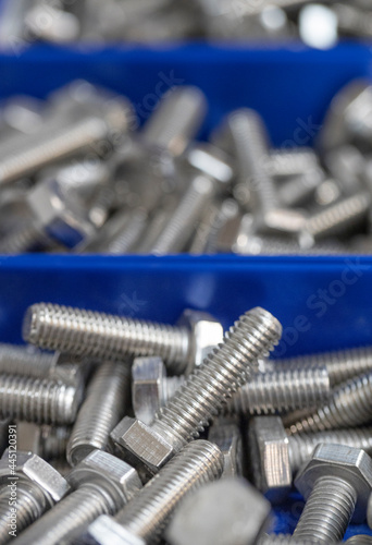Bolts and nuts in blue containers. 