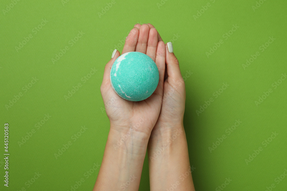 Female hands hold bath ball on green background Female hands hold bath ball on green background
