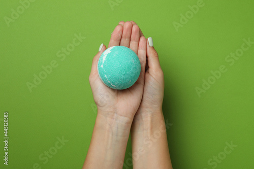 Female hands hold bath ball on green background
