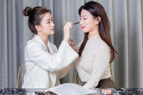 Two beautiful girlfriends doing makeup