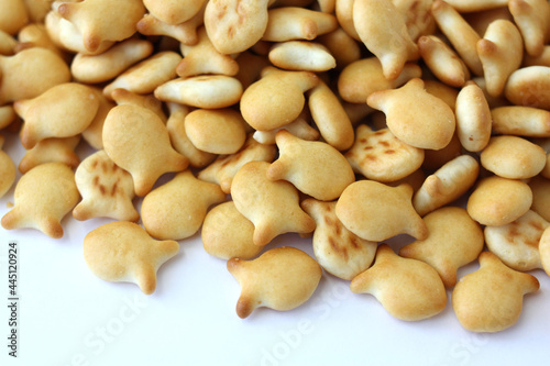 Heap of fish shaped cookies, salted crackers on a white background.