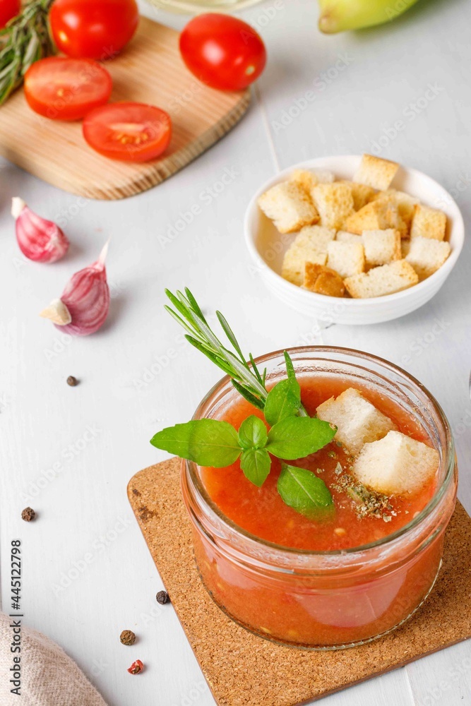 Cold gazpacho soup in a small jar,served with basil and croutons. Close-up on a light wooden background, vertical Cold gazpacho soup in a small jar,served with basil and croutons. Close-up on a light wooden background, vertical