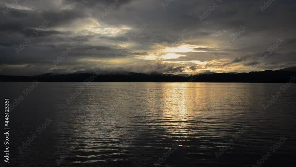 Calm sunset over a Norwegian fjord in the summertime. Beautiful sky, clouds and water. Contrast mountains. Calm sunset over a Norwegian fjord in the summertime. Beautiful sky, clouds and water. Contrast mountains.
