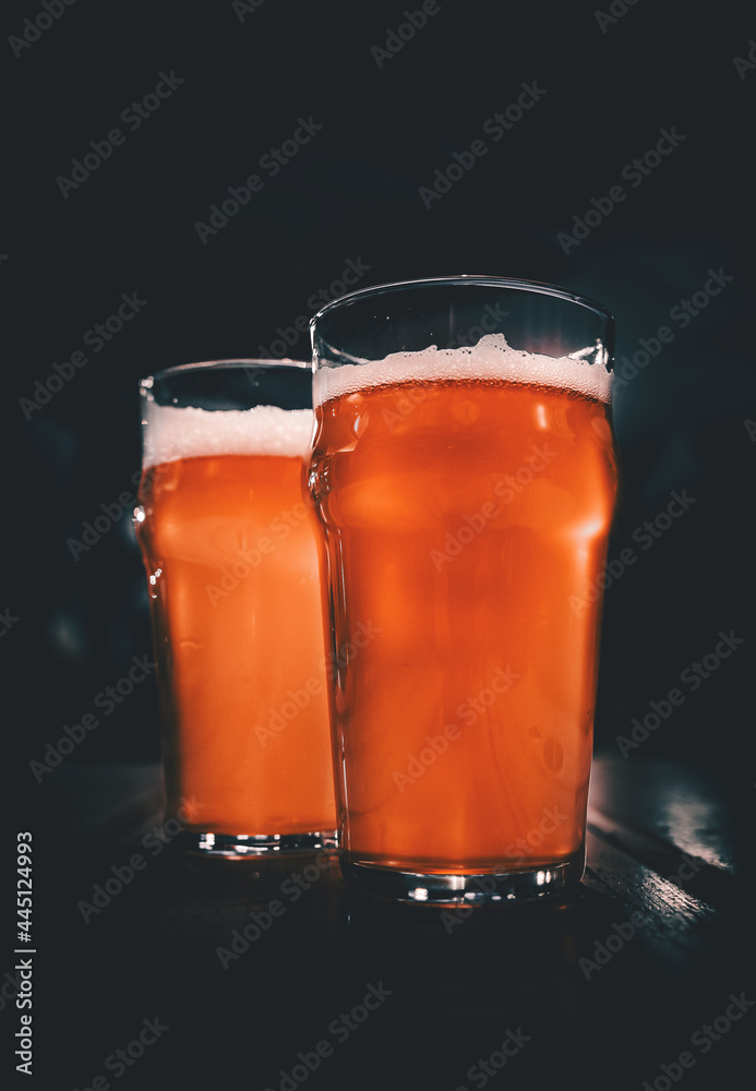 two glass of light beer stands on a table in a bar or pub two glass of light beer stands on a table in a bar or pub