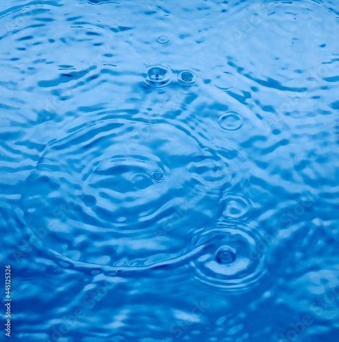 Circles of water on water surface. Blue color background