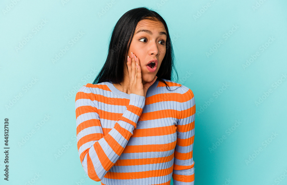 Young Venezuelan woman isolated on blue background being shocked because of something she has seen. Young Venezuelan woman isolated on blue background being shocked because of something she has seen.