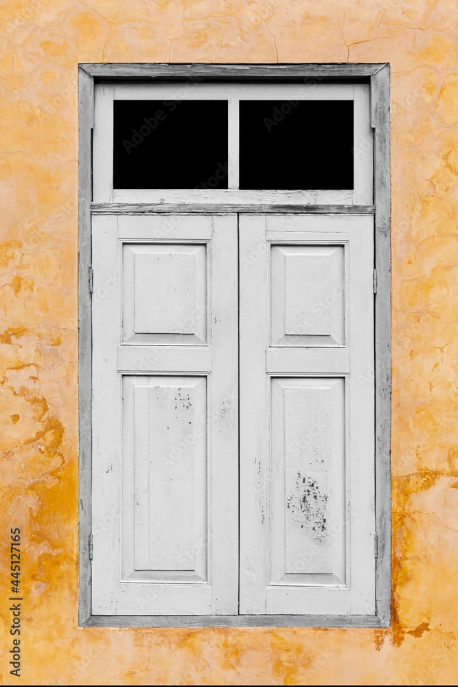 Old white vintage wooden windows and old yellow-brown cement wall