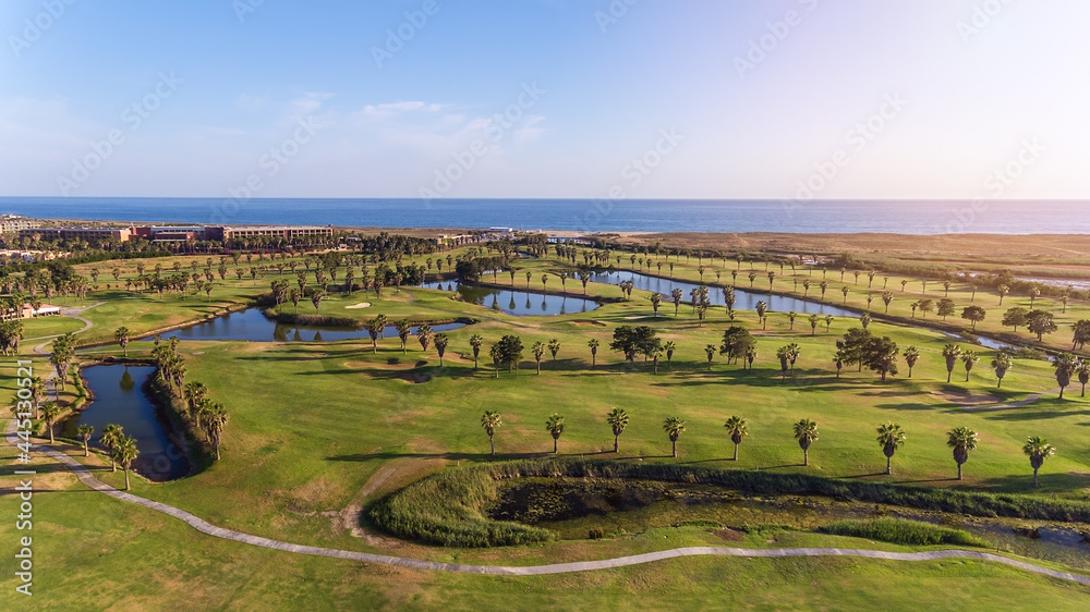 Green golf courses by the sea. Salgados beach. Portugal, Albufeira. Aerial view and high trees, sunny day 