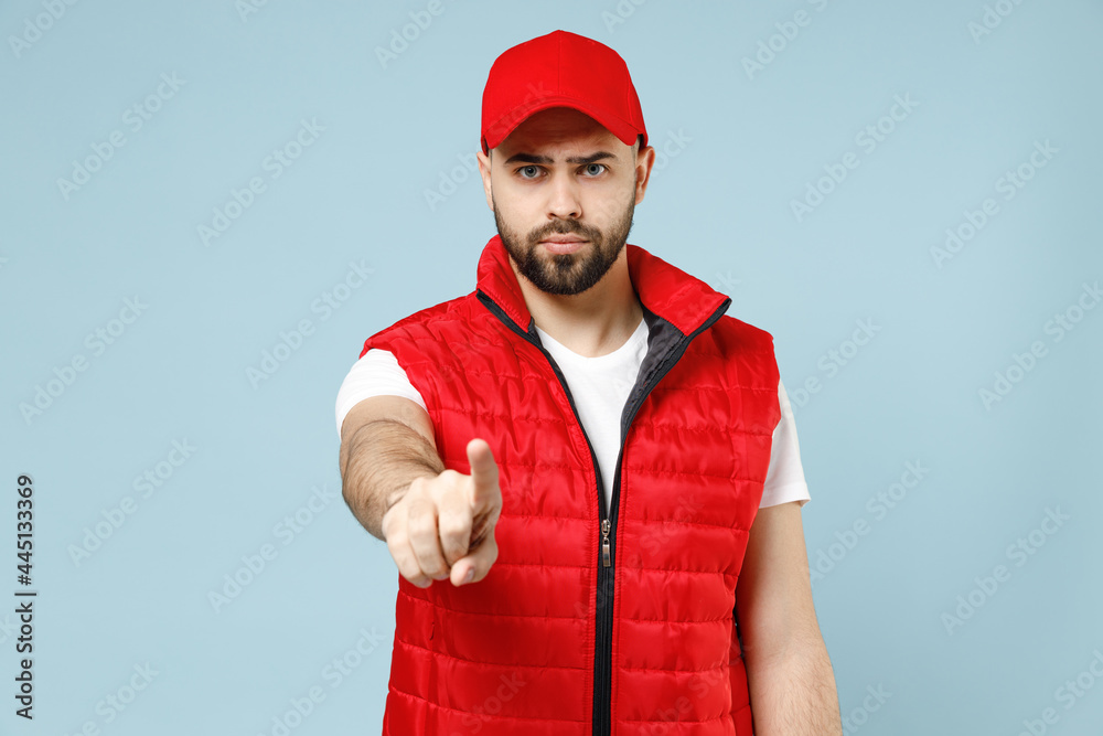 Professional sad tired worry delivery guy employee man in red cap white T-shirt vest uniform workwear work as dealer courier isolated on pastel blue color background studio portrait. Service concept. Professional sad tired worry delivery guy employee man in red cap white T-shirt vest uniform workwear work as dealer courier isolated on pastel blue color background studio portrait. Service concept.