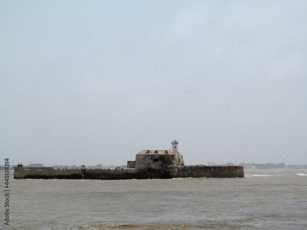 Pani Kotha or Alfiston jail located in sea of Diu, India. Imposing stone fortress and former prison featuring a lighthouse, cell blocks and a small chapel. Pani Kotha or Alfiston jail located in sea of Diu, India. Imposing stone fortress and former prison featuring a lighthouse, cell blocks and a small chapel.