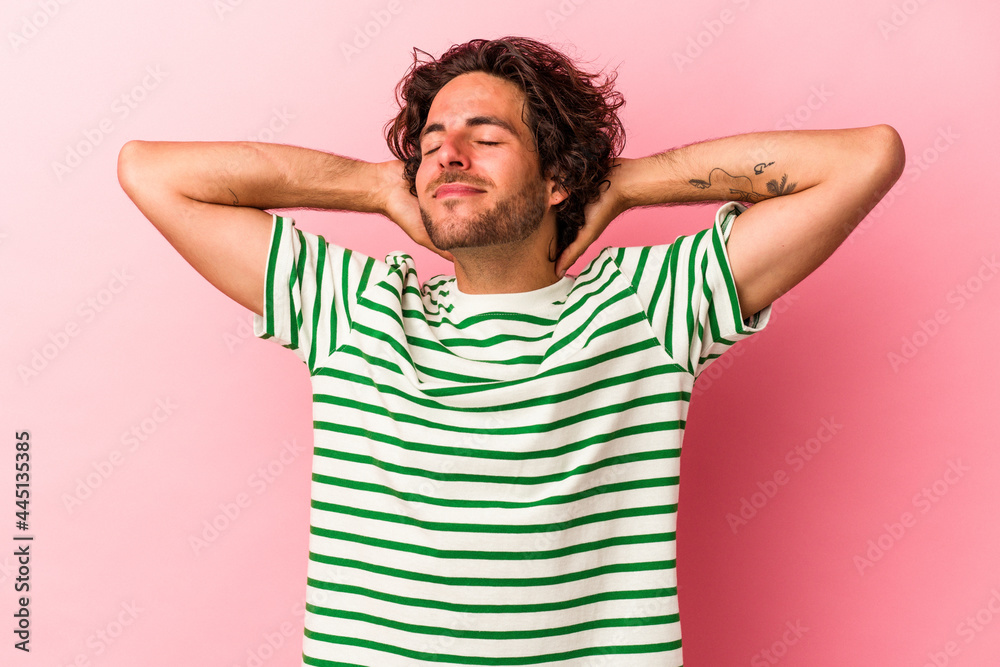 Young caucasian man isolated on pink bakcground feeling confident, with hands behind the head. Young caucasian man isolated on pink bakcground feeling confident, with hands behind the head.