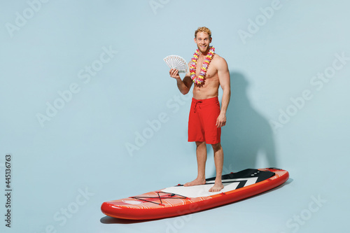 Photography Full length young winner rich man 20s wearing red shorts swimsuit stand on sup b