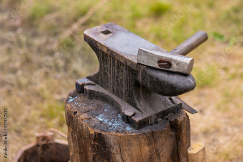 Hammer and blacksmith anvil at outdoor forge, workshop - selective focus, close up. Handmade, craftsmanship and blacksmithing concept