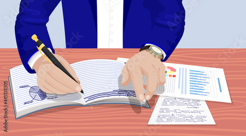 Businessman in suit sitting at table, writing with pen, works and draws pie chart in notebook. Business meeting in office. Hand with watch lies next to documents and sheets with information on table