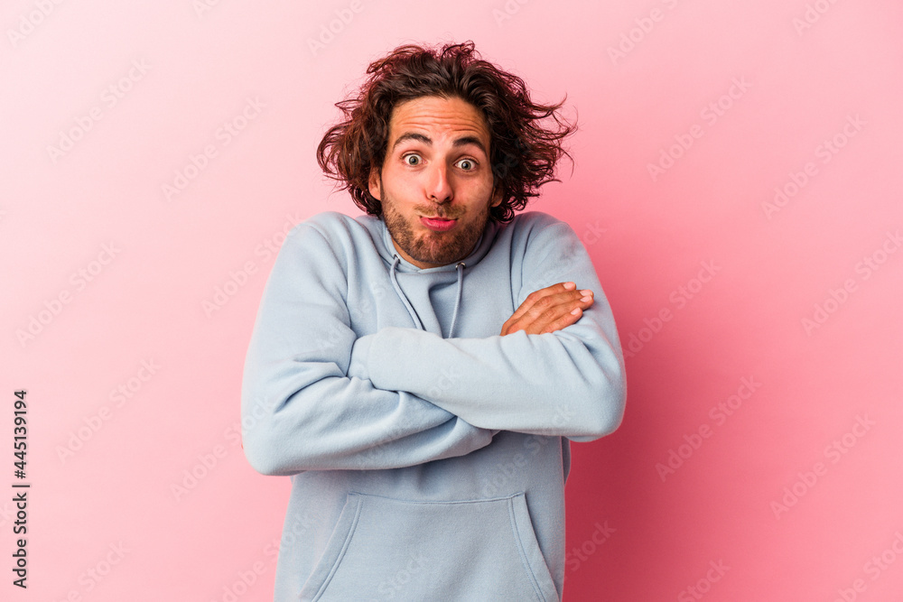 Young caucasian man isolated on pink bakcground shrugs shoulders and open eyes confused. Young caucasian man isolated on pink bakcground shrugs shoulders and open eyes confused.