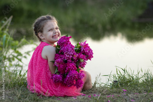 Little girl with bouquet of flowers smiling like a model