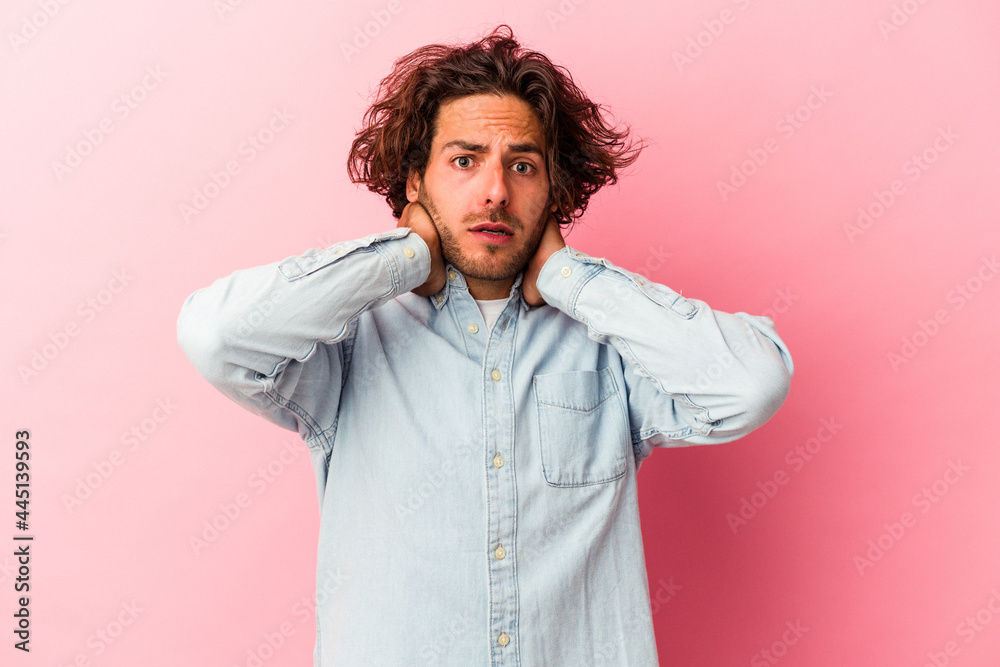 Young caucasian man isolated on pink bakcground touching back of head, thinking and making a choice. Young caucasian man isolated on pink bakcground touching back of head, thinking and making a choice.