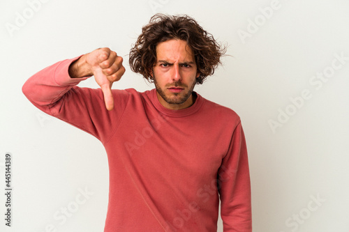 Young caucasian man isolated on white background showing thumb down and expressing dislike.