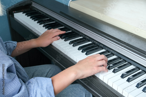 Online learning piano music using a laptop, learning to play the piano remotely, remote work. Laptop and a girl learn to play the piano remotely. Coronavirus pandemic in the world. School closure