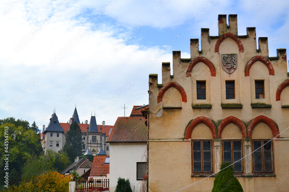 One of the streets of Žleby town with medieval old building and Žleby Castle in the foreground. Central Bohemian region, Czech Republic
