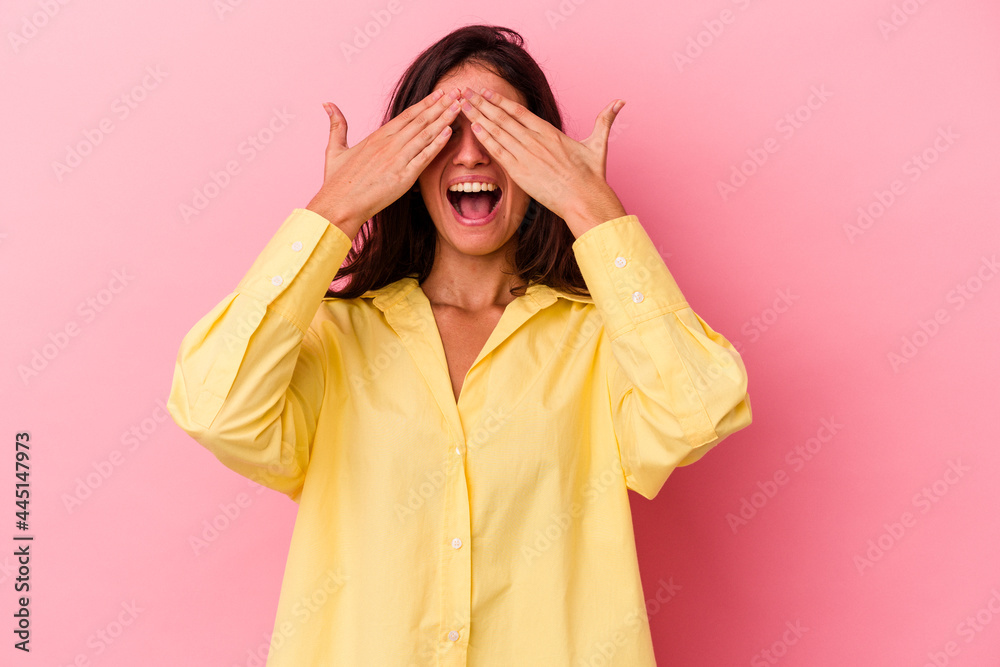 Young caucasian woman isolated on pink background covers eyes with hands, smiles broadly waiting for a surprise. Young caucasian woman isolated on pink background covers eyes with hands, smiles broadly waiting for a surprise.
