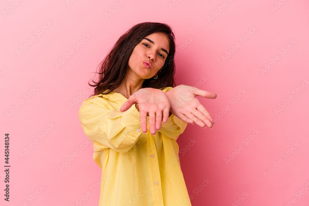Young caucasian woman isolated on pink background folding lips and holding palms to send air kiss. Young caucasian woman isolated on pink background folding lips and holding palms to send air kiss.