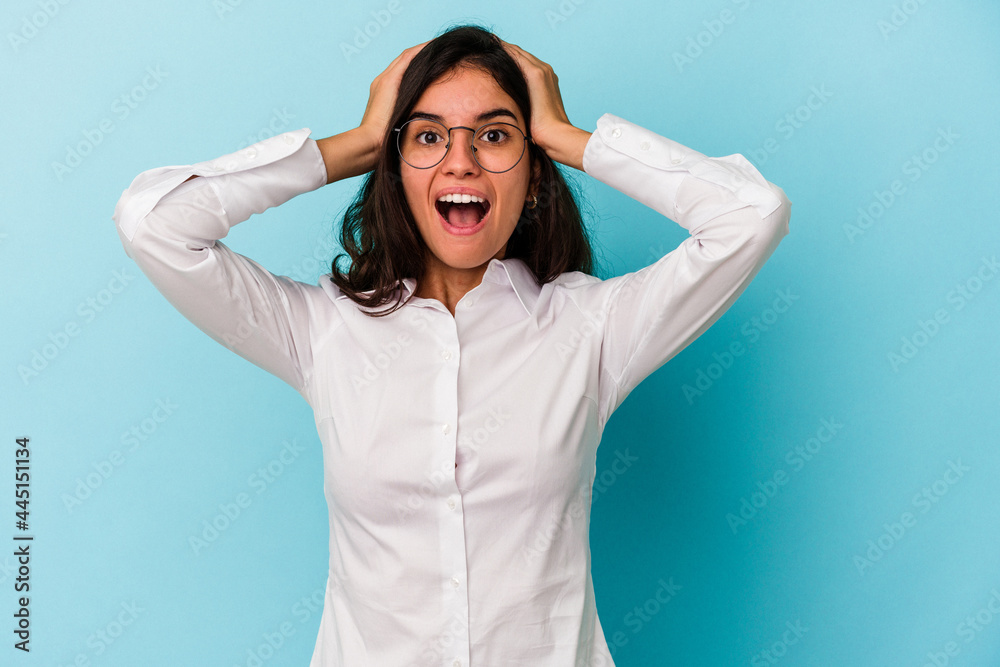 Young caucasian woman isolated on blue background screaming, very excited, passionate, satisfied with something. Young caucasian woman isolated on blue background screaming, very excited, passionate, satisfied with something.