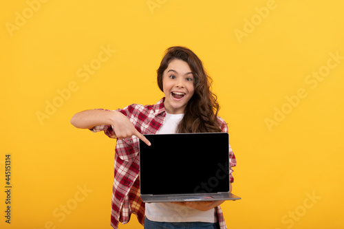amazed smart child pointing finger on laptop at school online lesson, school lesson