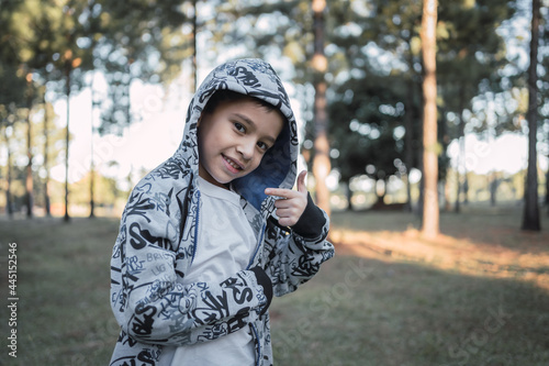 Portrait of a child wearing a hooded jacket outdoors.