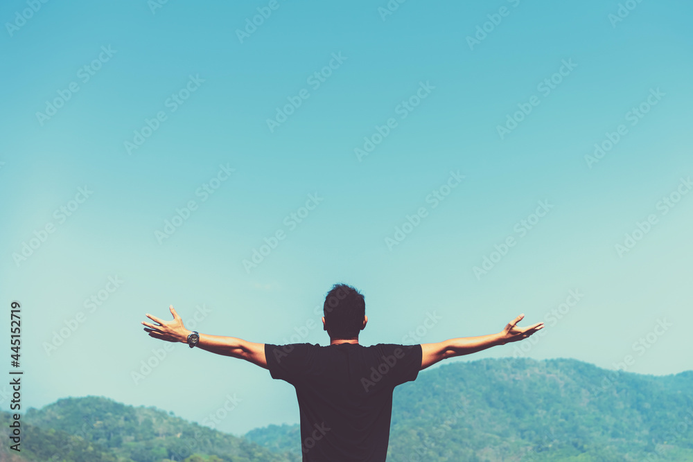 Copy space of man rise hand up on top of mountain and sunset sky abstract background.