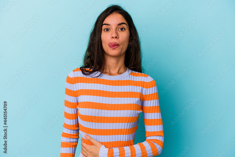 Young caucasian woman isolated on blue background touches tummy, smiles gently, eating and satisfaction concept. Young caucasian woman isolated on blue background touches tummy, smiles gently, eating and satisfaction concept.